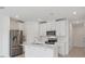 Open-concept kitchen with white cabinets, stainless steel appliances, and a center island at 16403 Bird Of Paradise Ave, Clermont, FL 34714