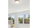 Bright living room featuring large windows, sliding glass doors, and neutral-toned walls at 16403 Bird Of Paradise Ave, Clermont, FL 34714