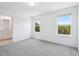 This bedroom features neutral paint, two windows and plush gray carpet with an attached bathroom at 16443 Bird Of Paradise Ave, Clermont, FL 34714