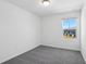 A brightly lit bedroom features plush carpeting, a window, and neutral tones at 16443 Bird Of Paradise Ave, Clermont, FL 34714
