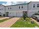 New townhome exteriors featuring a two-car garage, neutral colors, and a brick paved driveway at 16443 Bird Of Paradise Ave, Clermont, FL 34714
