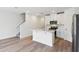 Open concept kitchen featuring white cabinets, stainless steel appliances, and modern fixtures at 16443 Bird Of Paradise Ave, Clermont, FL 34714