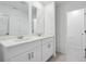 This bathroom features a double vanity with a white countertop, two mirrors, and tile floors at 16443 Bird Of Paradise Ave, Clermont, FL 34714