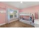 Bright pink bedroom with a bunk bed, shuttered window, and wood-look flooring at 189 Hammock Oak Cir, Debary, FL 32713