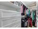 Well-organized walk-in closet featuring a Chanel bag, built-in shelving, drawers, and hanging racks at 189 Hammock Oak Cir, Debary, FL 32713