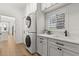 Bright laundry room featuring stacked washer and dryer, sleek countertops, and modern fixtures at 189 Hammock Oak Cir, Debary, FL 32713