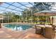 Screened-in pool and patio area with dining table and chairs, in a lush backyard at 189 Hammock Oak Cir, Debary, FL 32713