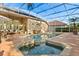 This screened-in pool features an attached hot tub, brickwork and an outdoor seating area at 189 Hammock Oak Cir, Debary, FL 32713