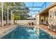 Screened-in pool area with comfortable seating, outdoor dining, and well-manicured landscaping at 189 Hammock Oak Cir, Debary, FL 32713