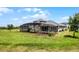 The back of the house has a screen in porch and is complimented by green grass and landscaping at 1910 Donahue Dr, Ocoee, FL 34761
