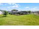 Expansive green backyard featuring a screened patio, mature trees, and a lush lawn at 1910 Donahue Dr, Ocoee, FL 34761
