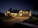 Inviting two-story home with a brick driveway, manicured lawn, and warm exterior lighting at night at 1910 Donahue Dr, Ocoee, FL 34761