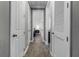 Hallway view showcasing wood-look tile floors and access to rooms with white doors at 1910 Donahue Dr, Ocoee, FL 34761