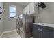 Well-equipped laundry room boasting stainless steel washer/dryer, gray cabinets, and a sink with storage at 1910 Donahue Dr, Ocoee, FL 34761