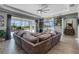 Open living room with tray ceiling, large sectional, shelving, and sliding glass doors to the lanai at 1910 Donahue Dr, Ocoee, FL 34761