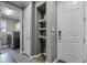 Inviting mud room featuring gray walls, wooden floors, storage shelving and leading to the laundry room at 1910 Donahue Dr, Ocoee, FL 34761