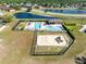 Aerial view of community pool, playground, and lush green common areas with pond in the distance at 19319 Briercrest Trl, Orlando, FL 32833