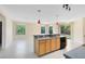 Open-concept kitchen featuring wood cabinetry, island, and a view of the bright and airy living space at 19319 Briercrest Trl, Orlando, FL 32833