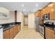 Well-lit kitchen with stainless steel appliances, granite counters, and adjacent hallway, showcasing modern design at 1998 Michael Tiago Cir, Maitland, FL 32751