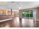 Open-concept living area with hardwood floors, sliding glass doors, and an adjoining kitchen space at 1998 Michael Tiago Cir, Maitland, FL 32751