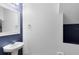 Stylish half bathroom with a modern sink and contrasting blue and white walls at 1998 Michael Tiago Cir, Maitland, FL 32751