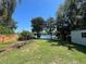 Tranquil backyard featuring a lush lawn, garden area, and partial lake views, creating a private outdoor retreat at 2154 Lake Christie Dr, Orlando, FL 32809