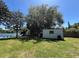 Spacious backyard featuring lush greenery, storage shed, and serene lake views at 2154 Lake Christie Dr, Orlando, FL 32809