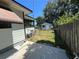 View of a well maintained side yard with shed and a partial lake view, surrounded by a wood fence at 2154 Lake Christie Dr, Orlando, FL 32809