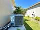 Air conditioner in the yard with a bush, providing efficient cooling for the house at 216 Grove Branch Rd, Winter Haven, FL 33880