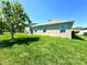 A spacious backyard with lush green grass, complemented by the home's exterior with large sliding glass doors at 216 Grove Branch Rd, Winter Haven, FL 33880