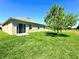A spacious backyard with lush green grass and large sliding glass doors leading to a serene outdoor space at 216 Grove Branch Rd, Winter Haven, FL 33880