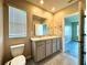 Bathroom with double sink vanity, a large mirror, toilet, and tile floors at 216 Grove Branch Rd, Winter Haven, FL 33880