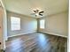 Spacious bedroom featuring wood-look flooring, a ceiling fan, and natural light from two windows at 216 Grove Branch Rd, Winter Haven, FL 33880