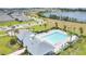 Stunning aerial view of the community pool, clubhouse, and playground near a scenic lake at 2731 Rowan St, Tavares, FL 32778