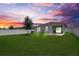 Spacious backyard with a white fence, green lawn, and a cozy fire pit area with pavers at 2731 Rowan St, Tavares, FL 32778