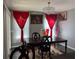 Dining room with a chandelier, red curtains, an area rug, and a dark wooden table at 2753 Monticello Way, Kissimmee, FL 34741