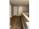 Hallway with wood floors featuring neutral paint, two doors, and access to rooms or additional space at 2753 Monticello Way, Kissimmee, FL 34741