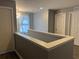 Hallway featuring modern chandelier, hardwood floors, and natural light from a window at 2753 Monticello Way, Kissimmee, FL 34741