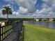 Scenic view of the pond surrounded by lush greenery, with a black fence around the edge at 2753 Monticello Way, Kissimmee, FL 34741