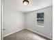 Vacant bedroom with neutral carpet, fresh paint, and natural light from a single window at 2845 Ellis Ave, Lakeland, FL 33803