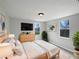 Bright bedroom featuring natural light, light wood floors, and a modern dresser with mounted TV at 2845 Ellis Ave, Lakeland, FL 33803