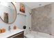 Well-lit bathroom featuring decorative tile accent wall, modern fixtures, and a round mirror at 3254 Oak Lake Pl # 137, Winter Park, FL 32792