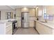 Well-lit kitchen featuring stainless steel appliances, wood-style cabinets, and stylish tile flooring at 3254 Oak Lake Pl # 137, Winter Park, FL 32792