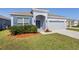 Single-story home with manicured lawn, blue shutters, and a two-car garage at 3532 Yarian Dr, Haines City, FL 33844