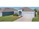 Single-story home with a well-manicured lawn, blue shutters, and two-car garage at 3532 Yarian Dr, Haines City, FL 33844