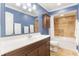 Bathroom with a wooden vanity, white sink, blue walls, and tiled shower-tub combo at 3823 Martin St, Orlando, FL 32806