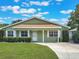 Charming single-story home with a well-manicured lawn, beautiful landscaping, and a paved driveway at 3823 Martin St, Orlando, FL 32806