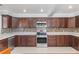 Spacious kitchen with stainless steel appliances, tile backsplash, and dark wood cabinets at 3823 Martin St, Orlando, FL 32806