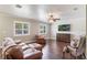 Elegant living room featuring hardwood floors, comfortable leather furniture, and a large TV at 3823 Martin St, Orlando, FL 32806