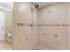 Shower with tile walls and floor, featuring decorative accents and a shower head at 3823 Martin St, Orlando, FL 32806
